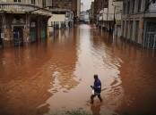 A man wades through an area flooded in Porto Alegre, Rio Grande do Sul state in Brazil. (AP PHOTO)