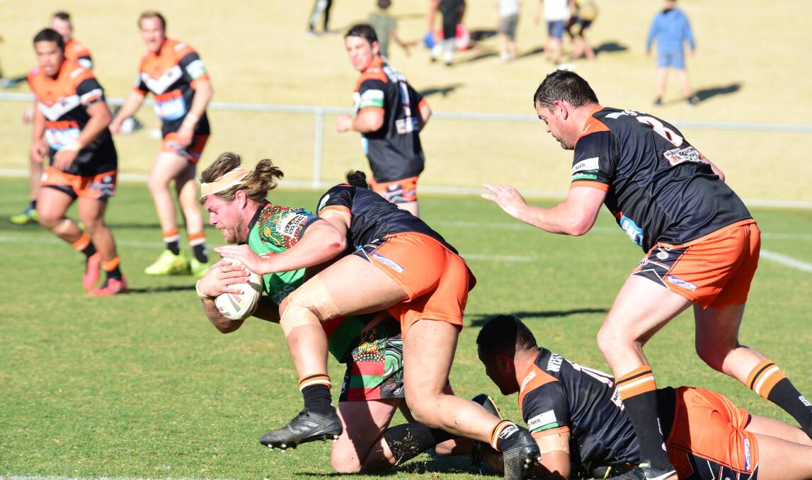 Caught: Rabbitohs front rower Ty Blanchett is dragged down by the Nyngan defence. Photo: PAIGE WILLIAMS
