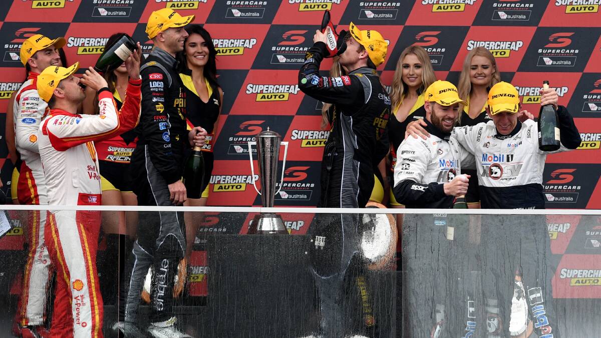 THE SHOEY: Bathurst 1000 champion David Reynolds gets stuck into a shoey as part of his race win celebrations on Sunday. Photo: Brendan Esposito