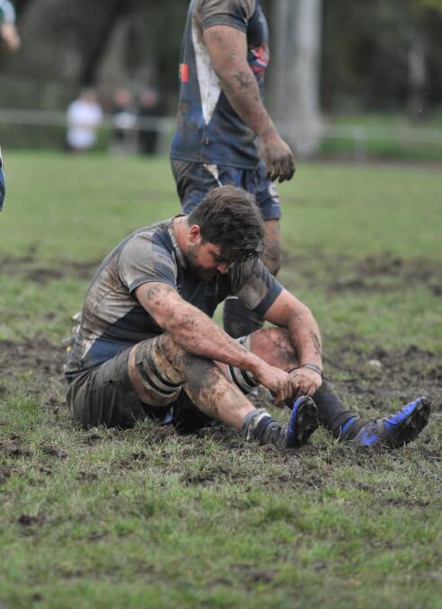 MUD: Forbes' Matt Coles sit in the mud after fulltime. Photo: JUDE KEOGH