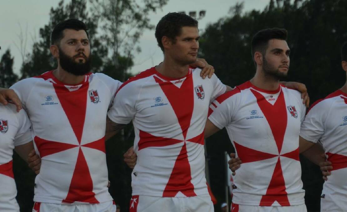 HONOUR: Jake Grace (centre) links arms with his teammates for the Maltese national anthem.