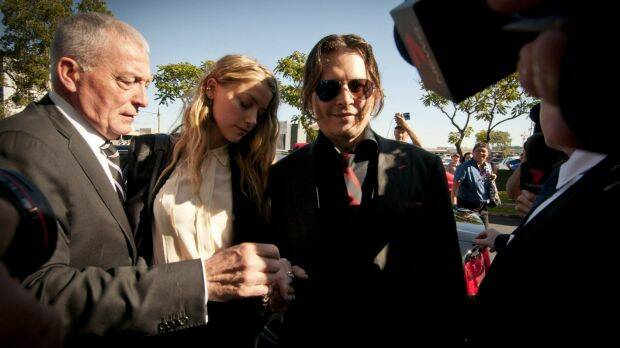 Actors Johnny Depp and his wife Amber Heard make their way through the media scrum. Photo: Robert Shakespeare