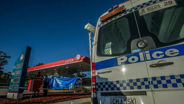NSW police officers and SES personnel attend the scene of a fatal stabbing at the Queanbeyan Caltex service station.  Photo: Karleen Minney