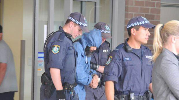 IN CUSTODY: Police with murderer Malcolm Naden after his capture in 2012.
