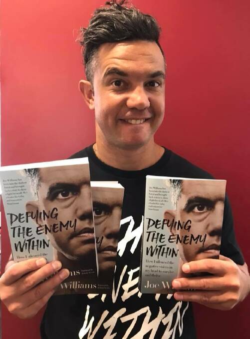 IN WRITING: Joe Williams with copies of his book 'Defying The Enemy Within'.