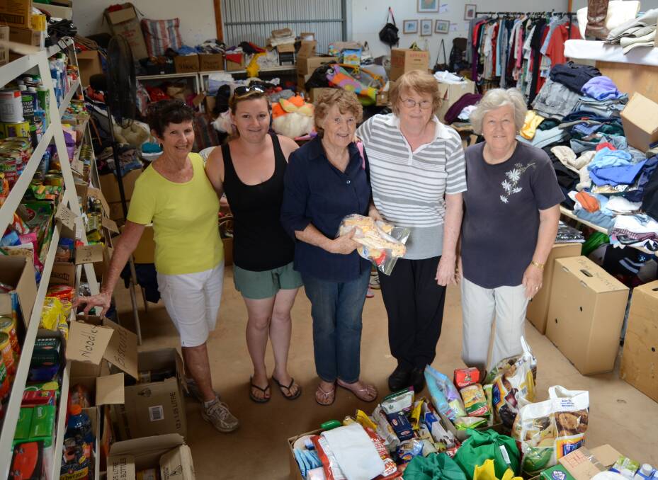 BOMBARDED: Pat Upston, Tania Ratcliff, Margaret Wilson, Joyce Redding and Wendy Hill among the piles of donations at the showground in Dunedoo. Photo: ELOUISE HAWKEY