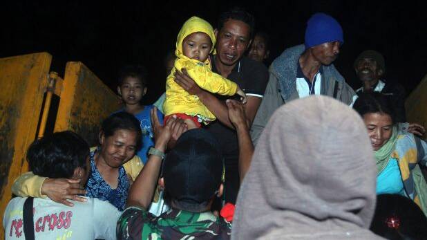 Rescuers assist villagers who were evacuated from their homes on the slope of Mount Agung. Photo: AP