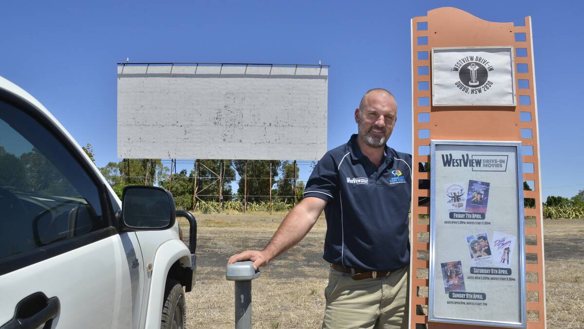Classic: Dubbo Regional Council's Jason Yelverton unveils a poster with the line-up of movies for the Westview Drive-In event to be held on April 7-9. Photo: BELINDA SOOLE
