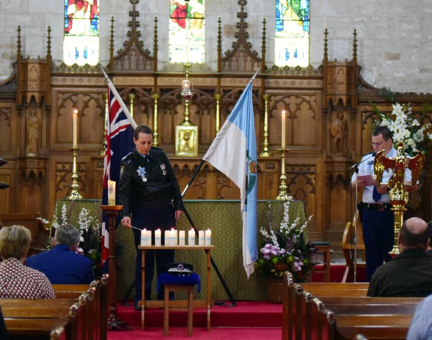 Remembrance: Senior Constable Ruth Handley lights candles as Sergeant Stephen Thompson reads the honour roll. Photo: BELINDA SOOLE