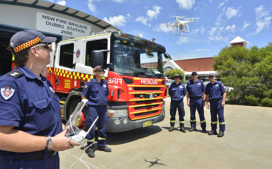 Eye in the sky: Relieving station officer and drone pilot Michael Harvey demonstrates the new technology's uses to Dubbo firefighters Charles Antonievich, Brad Edwards, Greg Croake and Chris Cusack. Photo: BELINDA SOOLE