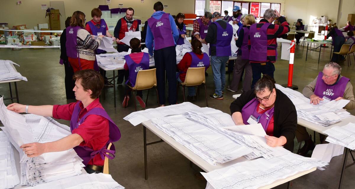 Count down: Secure zone officer Hamish Dickson (back, in red vest) and AEC workers resume tallying votes in Dubbo on Tuesday. See story on page 4. Photo: Belinda Soole