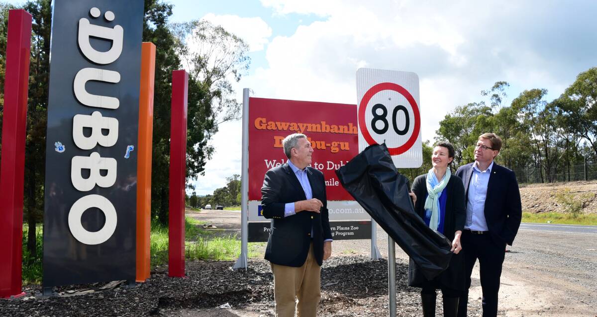 NO NEED FOR SPEED: NSW Roads Minister Duncan Gay, Sheri Dunn and Dubbo MP Troy Grant reveal the new 80 kilometre sign installed on the Newell. Photo: BELINDA SOOLE
