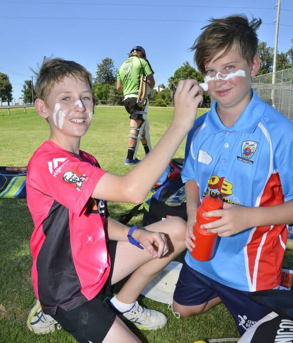 SUN SAFE: Kurt Barrett and Olliy Brown, both 12, lather on sunscreen before taking part in the first day of the Shaun Brown Cricket Camp in Dubbo on Wednesday. Photo: BELINDA SOOLE