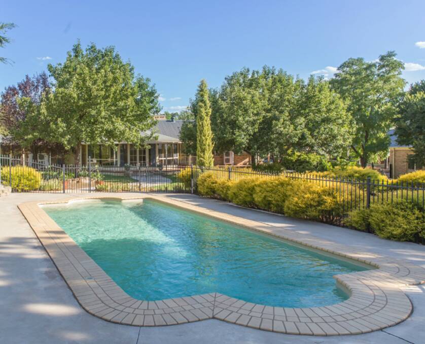 Outdoor living: There is a a sparkling in-ground pool with raised outdoor dining area. Photo: Contributed