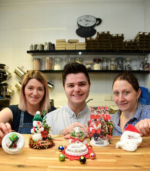 Getting into the Christmas spirit: Jess Ward, Jono Russo and Jo Russo with some of last years Christmas lid competition deisgns. Photo: Belinda Soole