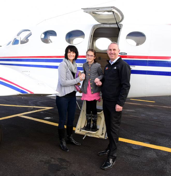 Flying high: Char Woodbury, with her daughter Emma and Wings 4 Kidz pilot Kevin Robinson board the plane to take Emma to Sydney for treatment. Photo: Belinda Soole