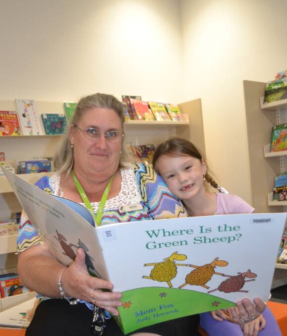 Books galore: Dubbo Macquarie Regional Library assistant Michelle Betts reads to Summer-Lee Taylor, 6. Photo: Taylor Jurd