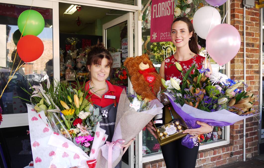 LOVE BLOOMS: Jackie Pratten and Tegan Shields hold flowers arranged for customers celebrating Valentine's Day. :Photo: KIM BARTLEY