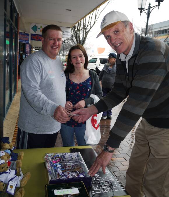 LEGACY WEEK: Andrew and Nikola Morley buy merchandise from Greg Salmon who manned the Dubbo Legacy stall in Macquarie Street on Wednesday morning. Photo: KIM BARTLEY