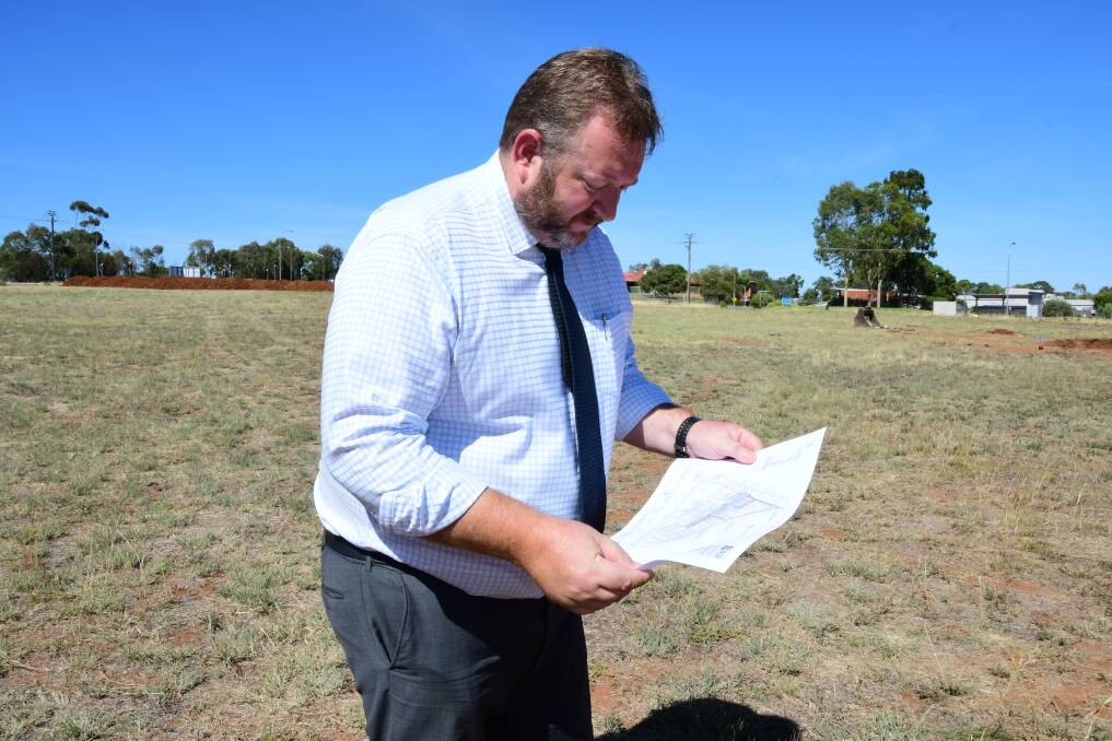MASTER PLAN: Managing director of not-for-profit Macquarie Home Stay Rod Crowfoot  examines a copy of its master plan as heavy machinery gets to work on its east Dubbo property. Photo: BELINDA SOOLE