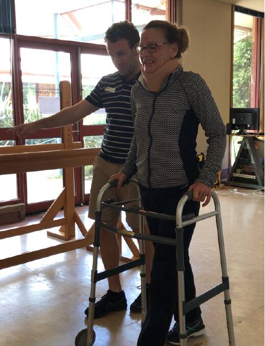 On the road to recovery: Ange Ednie is given some guidance to walk again using a frame.