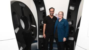 Sameer Datwani and Michelle McRae from Pinnacle Dermatology inside the 3D total body imaging system. Picture by Jude Keogh