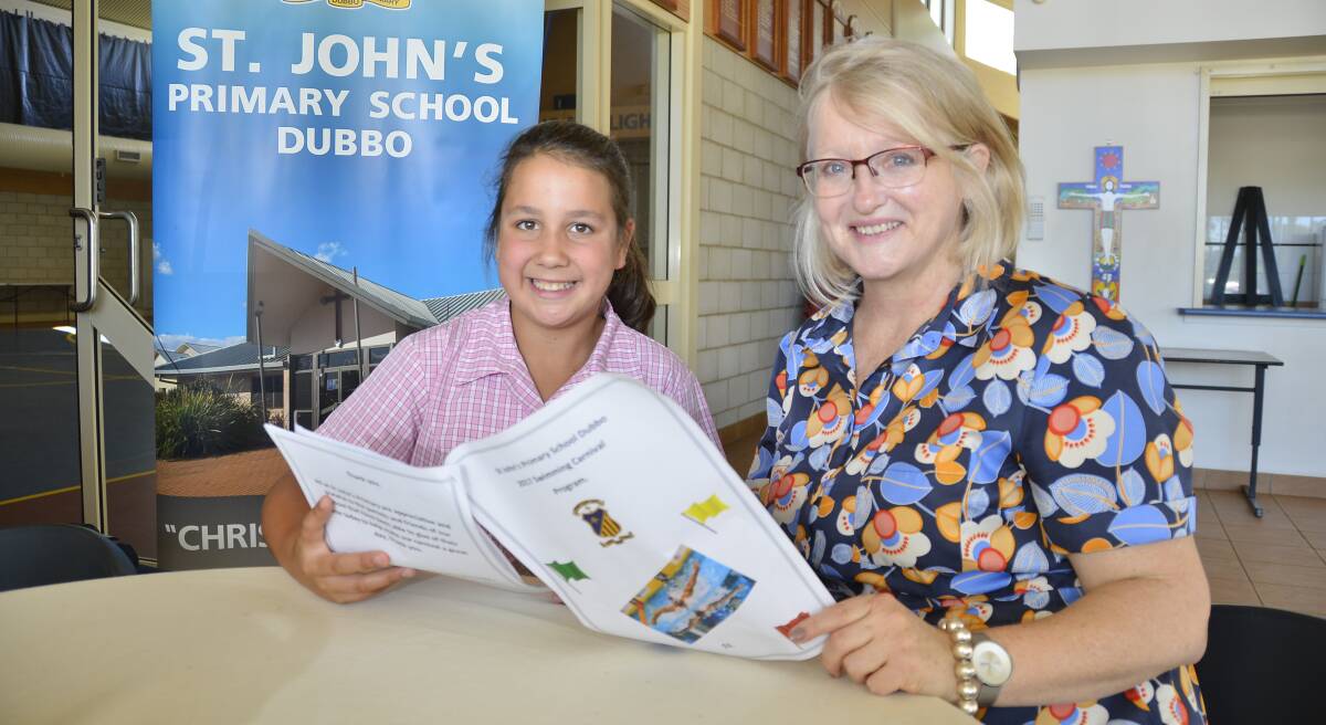 RECORD-SETTERS: Aspen Moore and Helen Clatworthy look over the St John's swimming records when meeting on Monday. Photo: BELINDA SOOLE