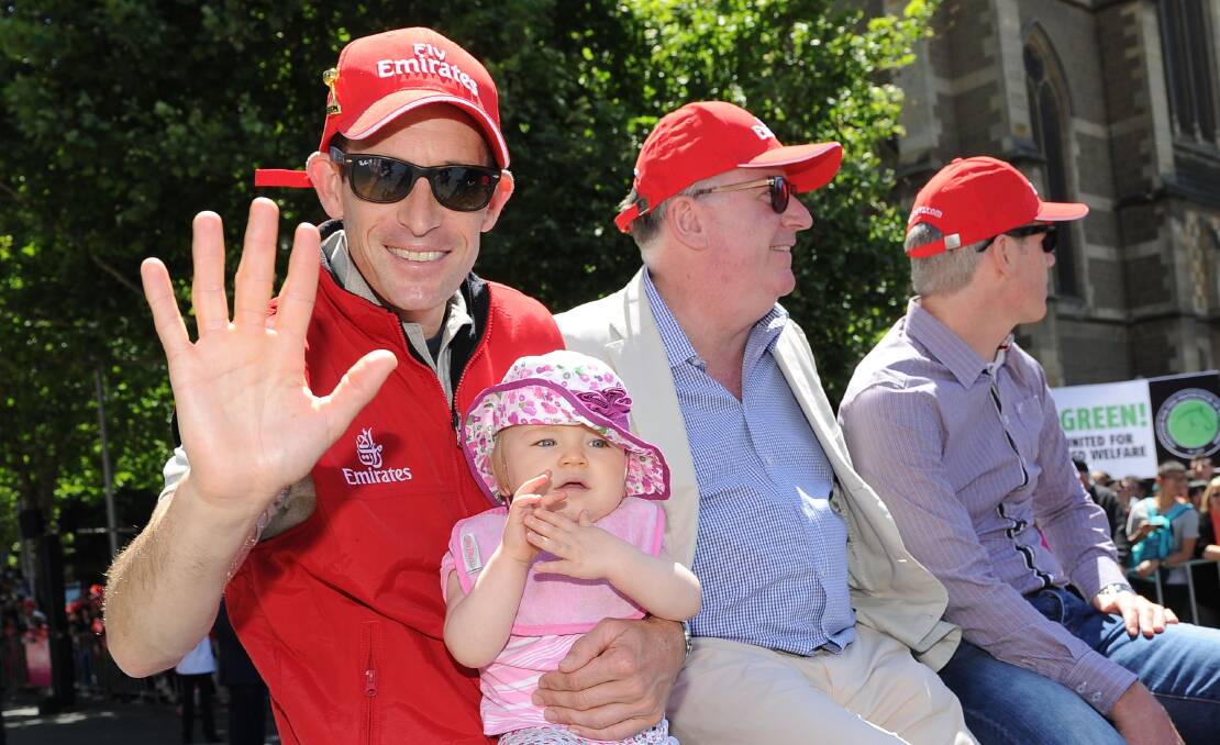 HIGHLIGHTS: Hugh Bowman and one of his daughters at the Melbourne Cup parade in 2014, one of the many times he has been involved in the famous race. Photo: GETTY IMAGES