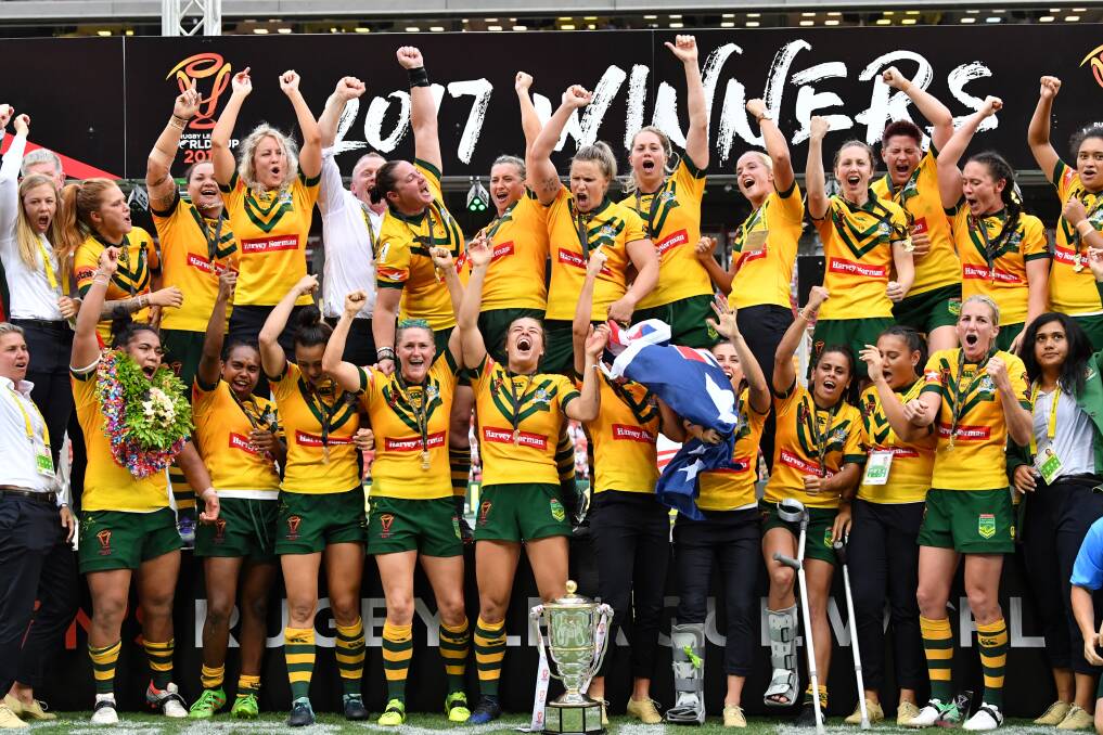 CELEBRATE: Brad Donald (back row, white shirt) and the Jillaroos celebrate winning the Women's Rugby League World Cup on Saturday. Photo: DARREN ENGLAND/ AAP