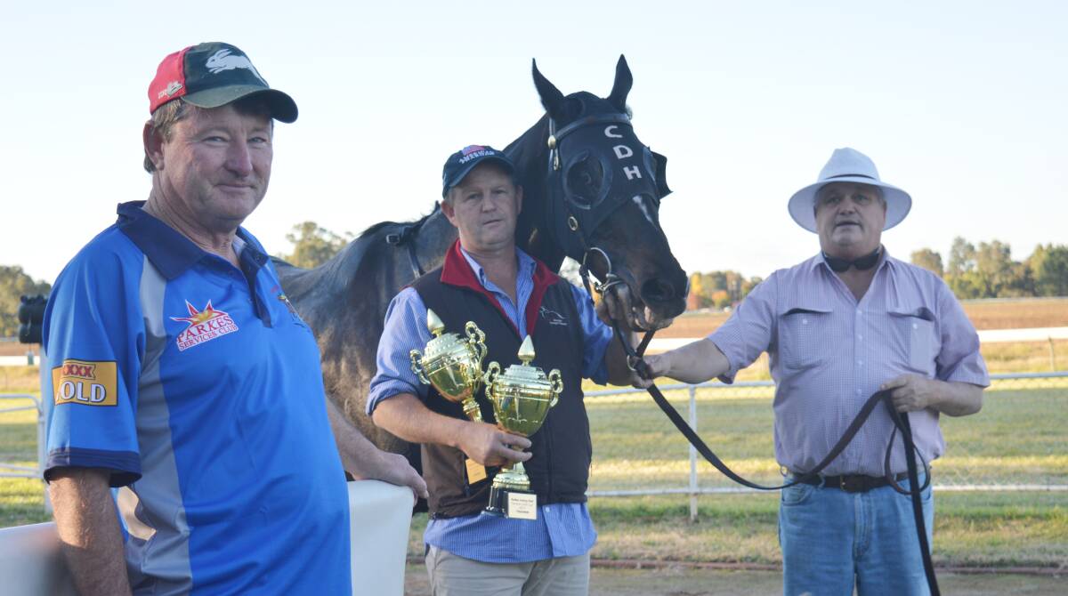 VICTORY: Parkes Jockey Club president Mark Ross (left) and committee member Ralph Smith (right) with trainer Chris Heywood and Leucura. Photo: PARKES CHAMPION POST