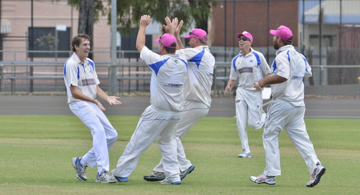 MOBBED: Teenage seamer James Hughes (left) celebrates with his Macquarie teammates after claiming one of his six impressive wickets against leaders RSL-Colts at No. 1 Oval on Saturday. Photo: BELINDA SOOLE