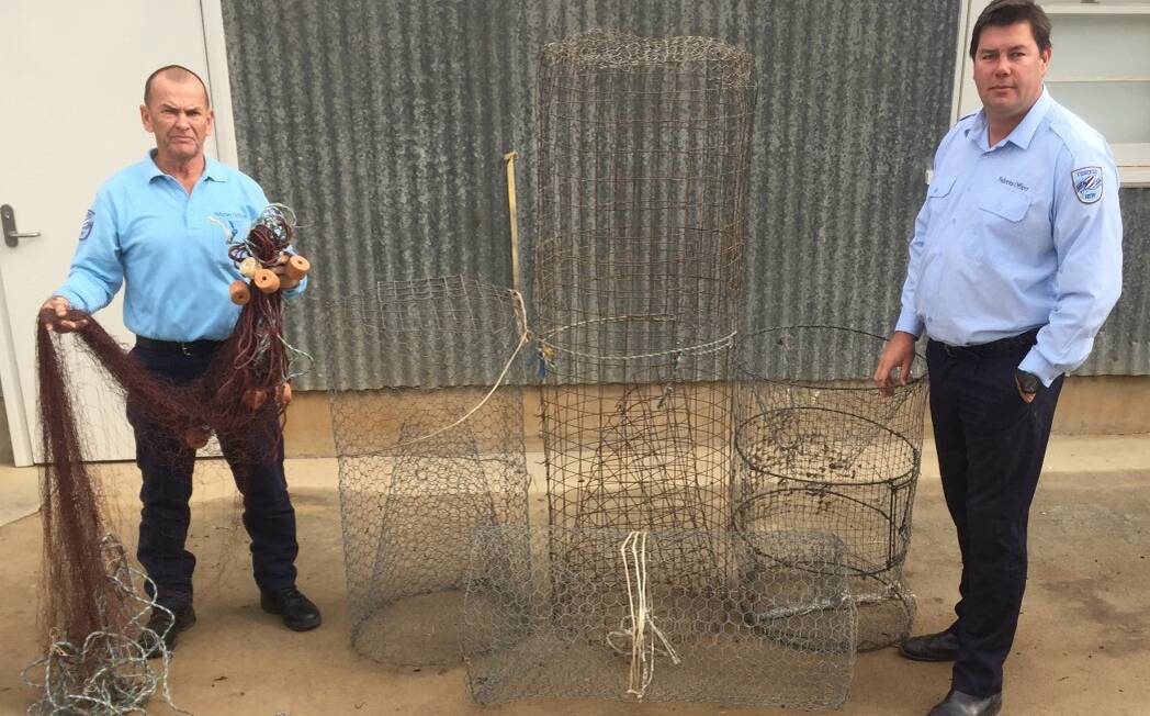 CAUGHT: The use of fish traps, nets and lines is a serious and ongoing issue throughout inland waterways. Pictured are NSW Fisheries officers.