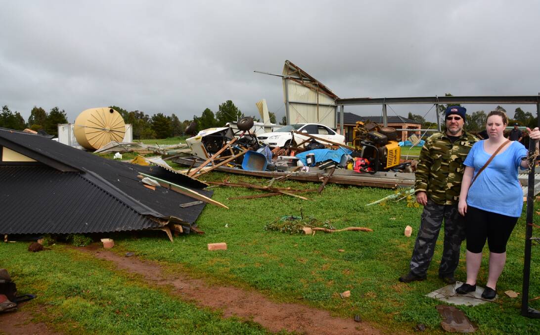 Devastating: Frank and Keeley Lappa stand in front of the their damaged shed and the roof of their house after a tornado caused tens of thousands of dollars of damage. Photo: BELINDA SOOLE