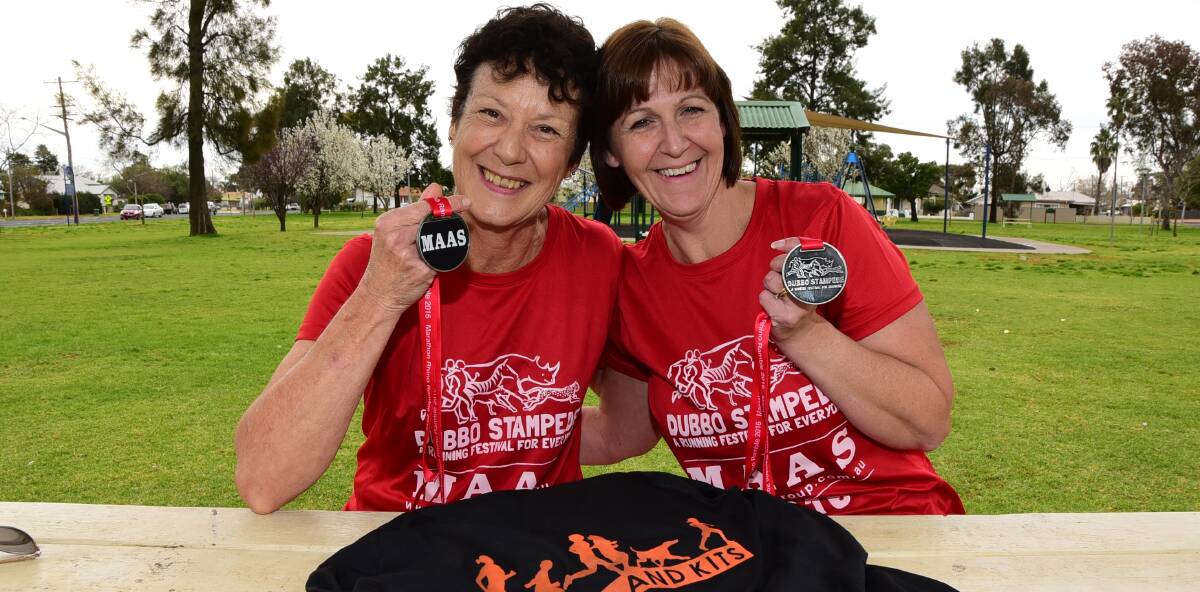 Can't stop smiling: Helen Yeo and Toni Fernando with their medals for completing the Dubbo Stampede marathon. Photo: BELINDA SOOLE