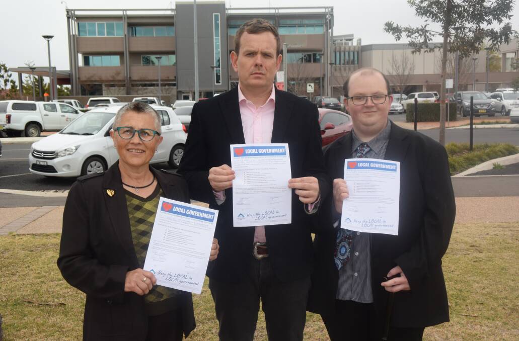 Cut it out: Kris Stevens, Stephen Lawrence and Cody Jones with their signed pledges to take a stand against privatisation and outsourcing.