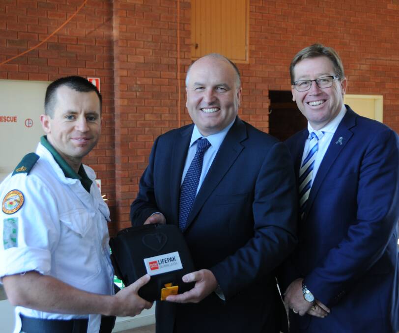 LIFE-SAVER: Dubbo VRA captain David Chenhall is presented the defibrillator by Minister for Emergency Services David Elliott and Dubbo MP Troy Grant.