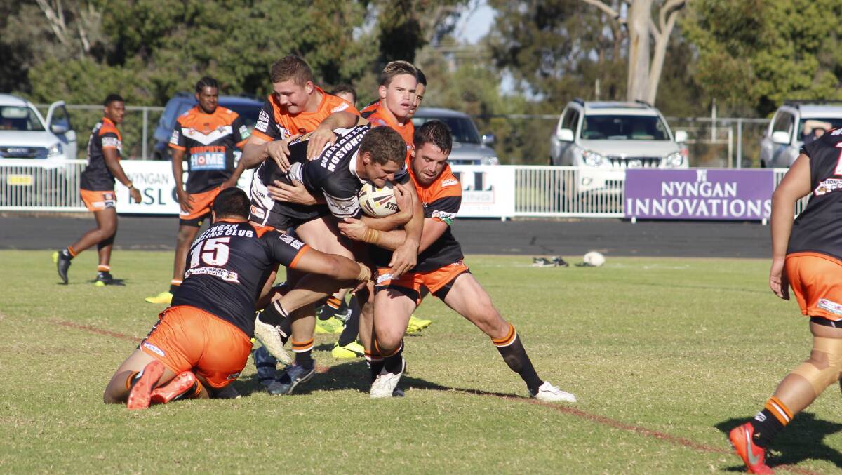 Tigers defenders Reece Goldsmith and Brett Howard take down Forbes captain Jake Grace at during their match at Larkin Oval on Sunday. Photo: STACEY WRIGHT
