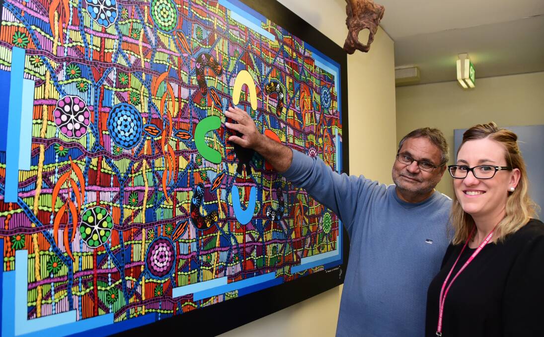 Strong significance: Aboriginal artist Robert Mackay explains his painting “A Window of Opportunity” to Dubbo College art teacher Casey Shirm. Photo: BELINDA SOOLE