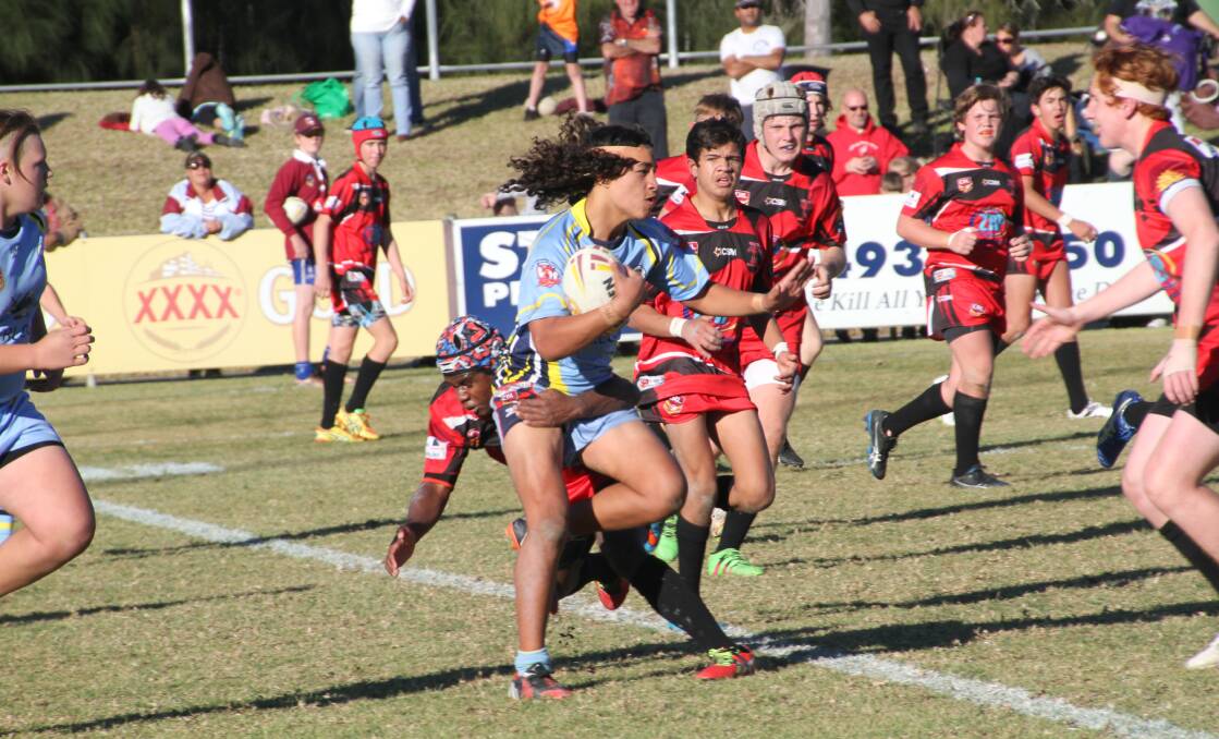 VALIANT EFFORT: Group 11 under 14s (red and black) put up a strong performance but were beaten by the Central Coast, 36-6. Photo: ADAM KIDD