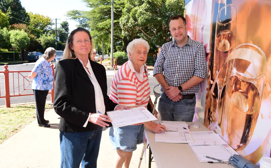 Vicki Mackay and Ben Shields collect signatures, including that of Ellen Stanmore (centre) for a petition against a third bin in Dubbo. Photo: BELINDA SOOLE