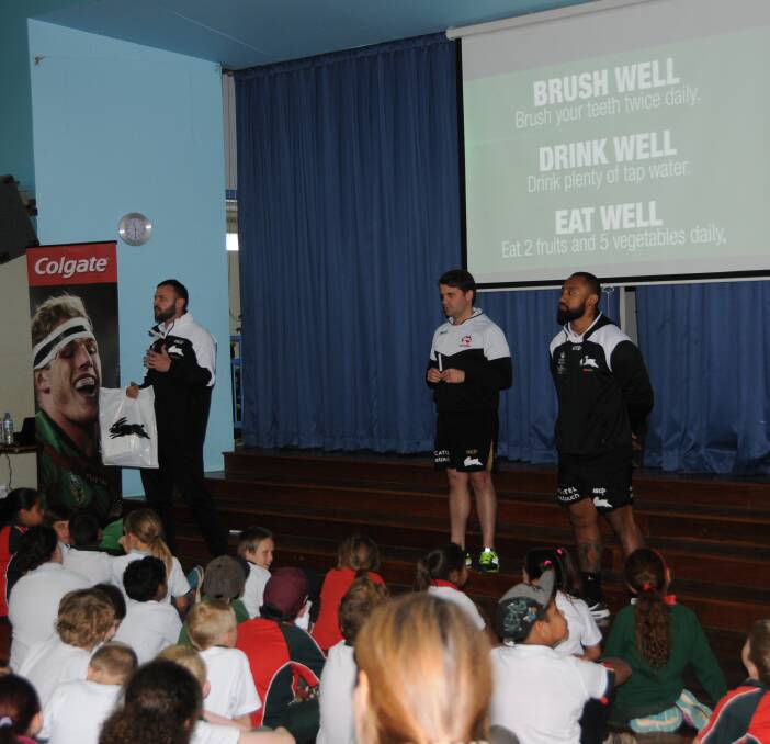 Important message: Beau Champion and Roy Asotasi, with Souths Cares general manager Brock Schaefer (centre) explaining the importance of brushing to Dubbo students. Photo: MARK RAYNER