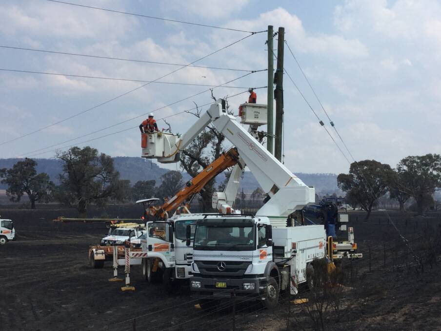 PITCHING IN: Dubbo-based Essential Energy crews assist in restoring power 
in the Coolah area. Photo: SUPPLIED