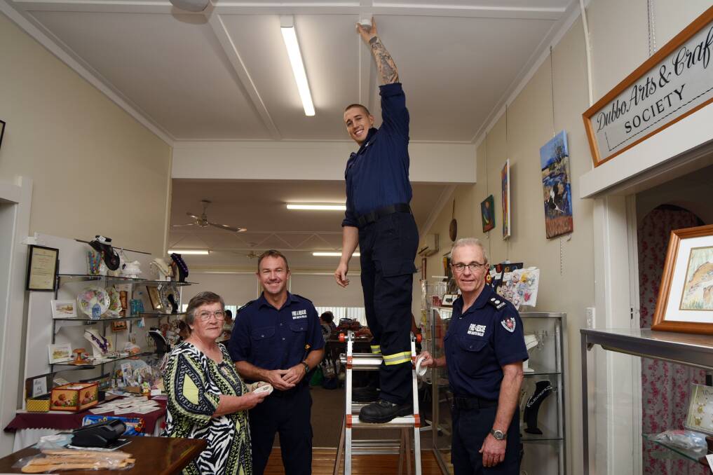 SAFETY FIRST: Dubbo Arts and Crafts Society public officer Ann Crannis with Dubbo firefighters Chris Cusack, Kurt Ryan and Mark Weir as they install smoke alarms at the arts and crafts centre. Photo: BELINDA SOOLE