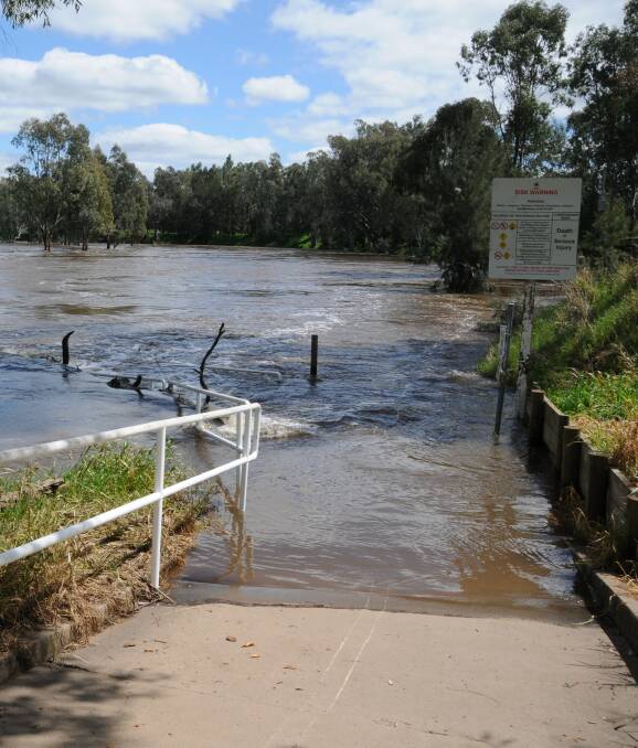 No end in sight: The pathway disappears into the river at Tamworth Street, as flood warnings remain in place for a saturated Central West. Photo: JENNIFER HOAR