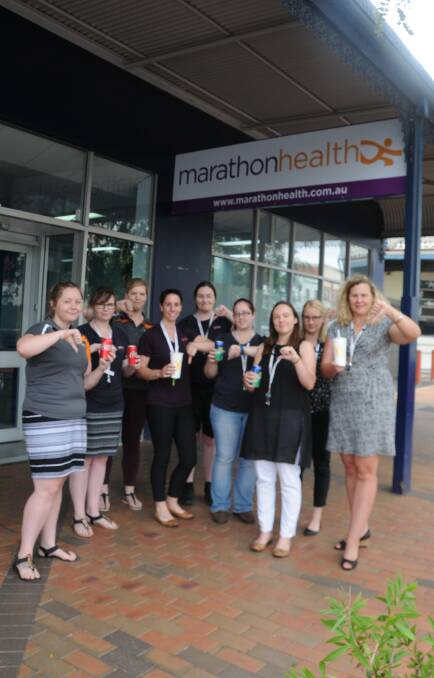 DRINK LESS: Marathon Health team members with some of the sugary drinks they think people should drink less of. Photo: JENNIFER HOAR