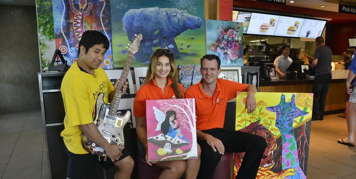 McHappy to help: Ronald McDonald House volunteers Prasong Johnson and Fleur and Ronald Pors with some of the artworks being auctioned as part of the McHappy Day fundraiser. Photo: BELINDA SOOLE