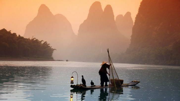 A man fishes with cormorants on a river.  Photo: 123rf.com