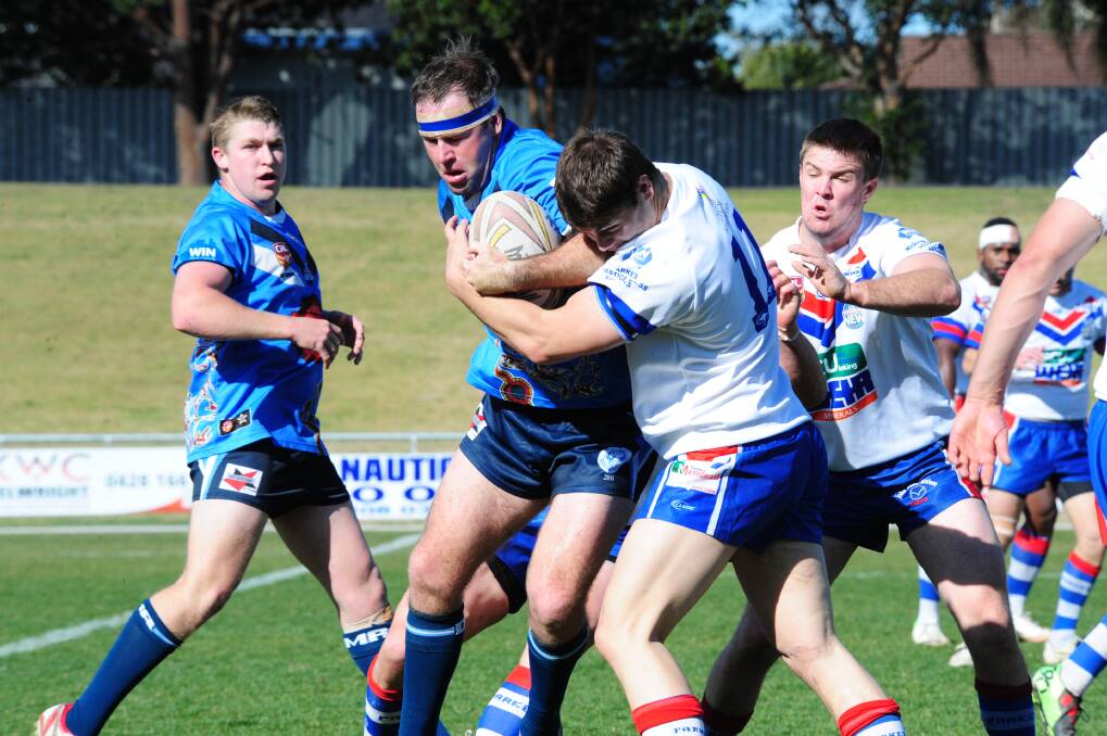 Zac Rennick tries to power his way through the Parkes defence during Macquarie's 48-24 win yesterday. 		         Photo: LOUISE DONGES