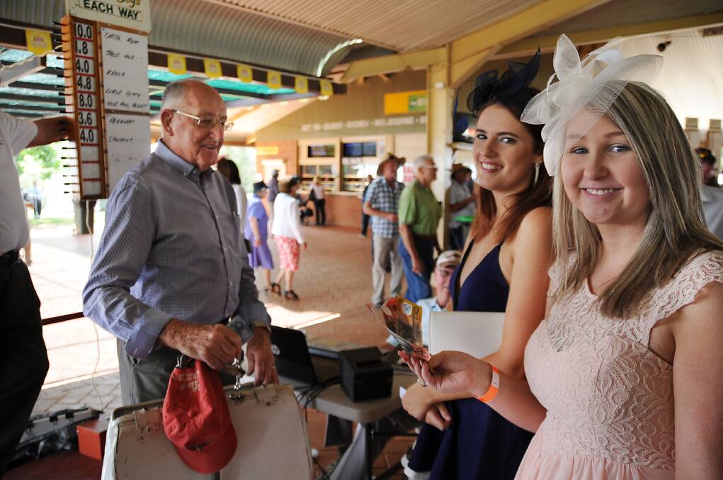 Winning big at the Melbourne Cup races in Dubbo were Leah Sayers and Amber Teale while taking the bets were Darcy Brooks and Noel Teys (background). 
													   Photo: BELINDA SOOLE