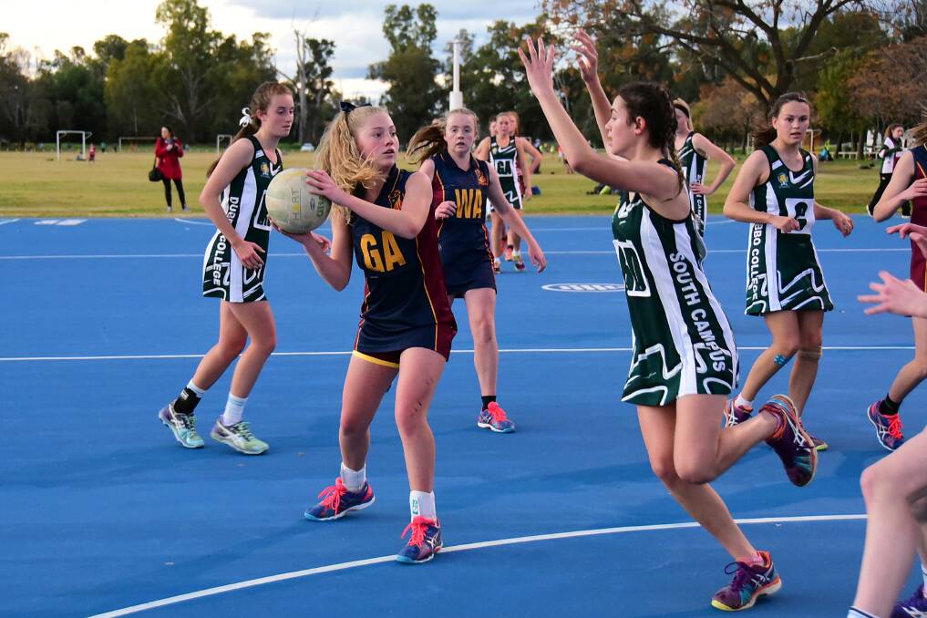 St John's player Georgie Conway maintains possession under pressure from Dubbo College's Georgia Benton Bryant during the Ken Eggleton Cup netball on Thursday afternoon. 	Photo: BELINDA SOOLE